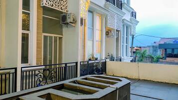 A building with a balcony, decorative metal railings, and a water feature.