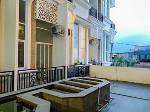 A building with a balcony, decorative metal railings, and a water feature. - Urban Loft Studio At Apartment Apple 1 Condovilla (Jakarta)