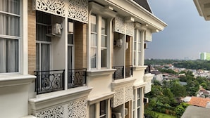 Um edifício com várias andares, varandas ornamentadas e grandes janelas.