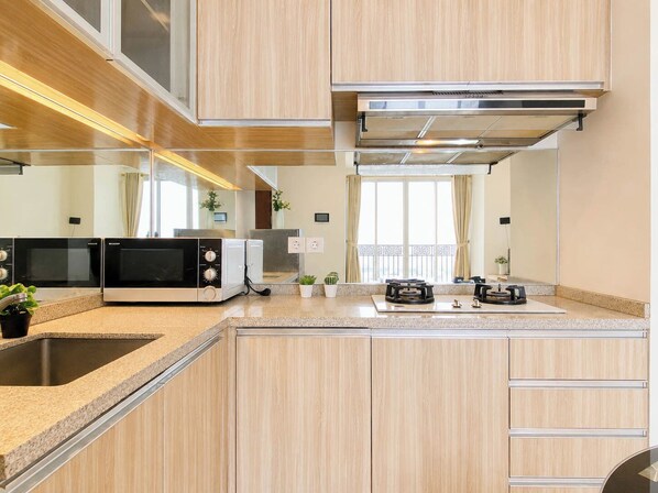 Eine moderne Küche mit integrierten Geräten, einer Arbeitsplatte aus Granit und Blick ins Freie.