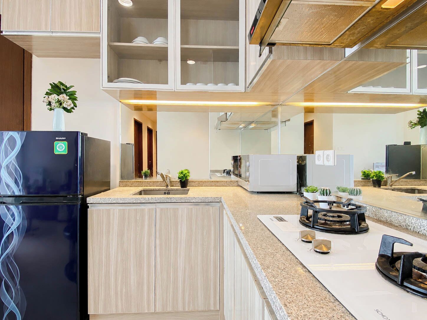 A modern kitchen with a built-in refrigerator, a sink, and a stove.