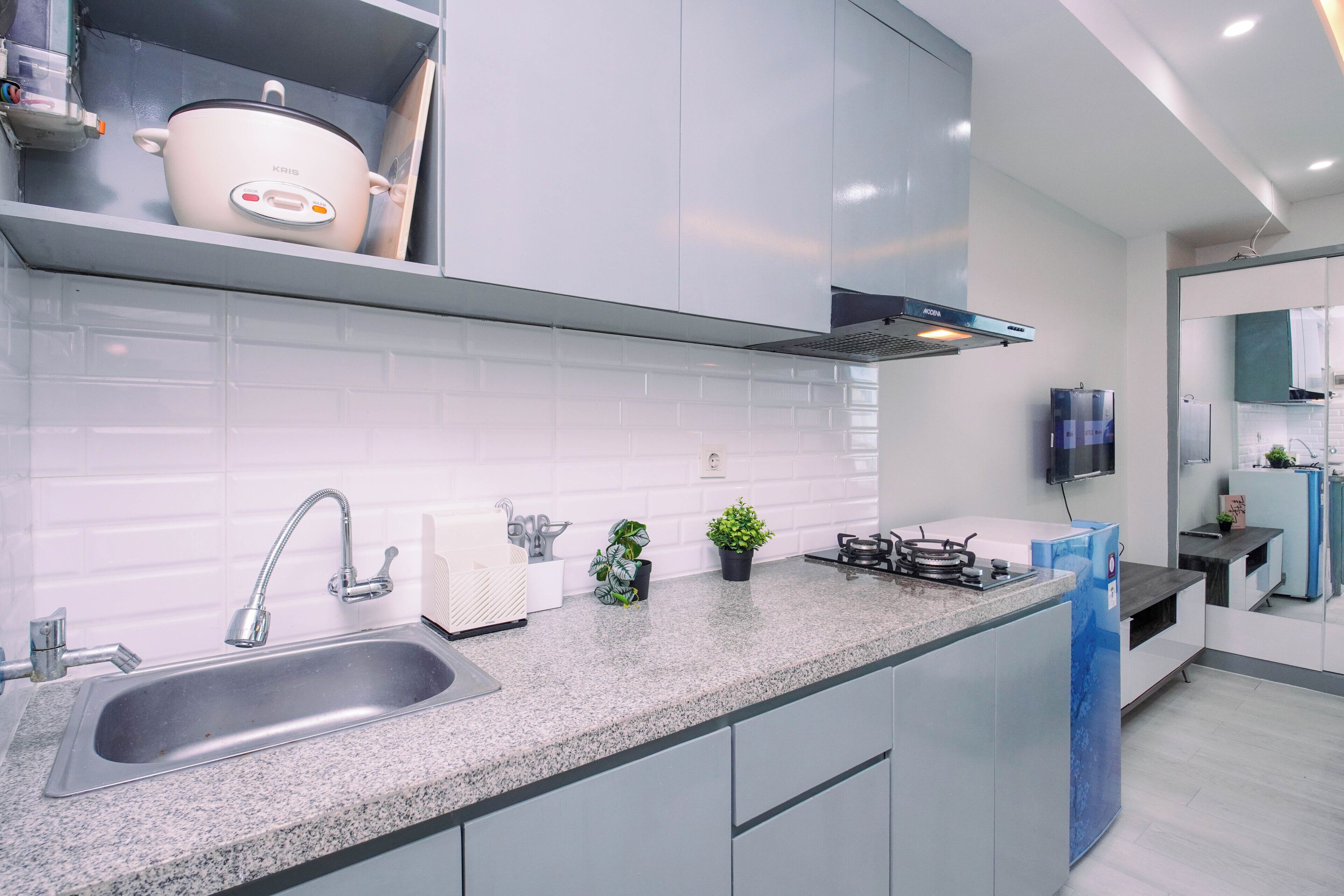 A modern kitchen with a granite countertop, stainless steel sink, and a built-in stove.