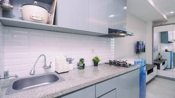 A modern kitchen with a granite countertop, stainless steel sink, and a built-in stove.