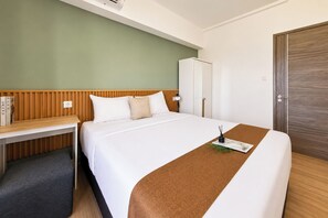 Ein Hotelzimmer mit einem Bett, einem Schreibtisch, einem Kleiderschrank und einer Tür.