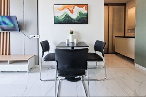 Ein moderner Essbereich mit Tisch, Stühlen und einem Bild an der Wand.