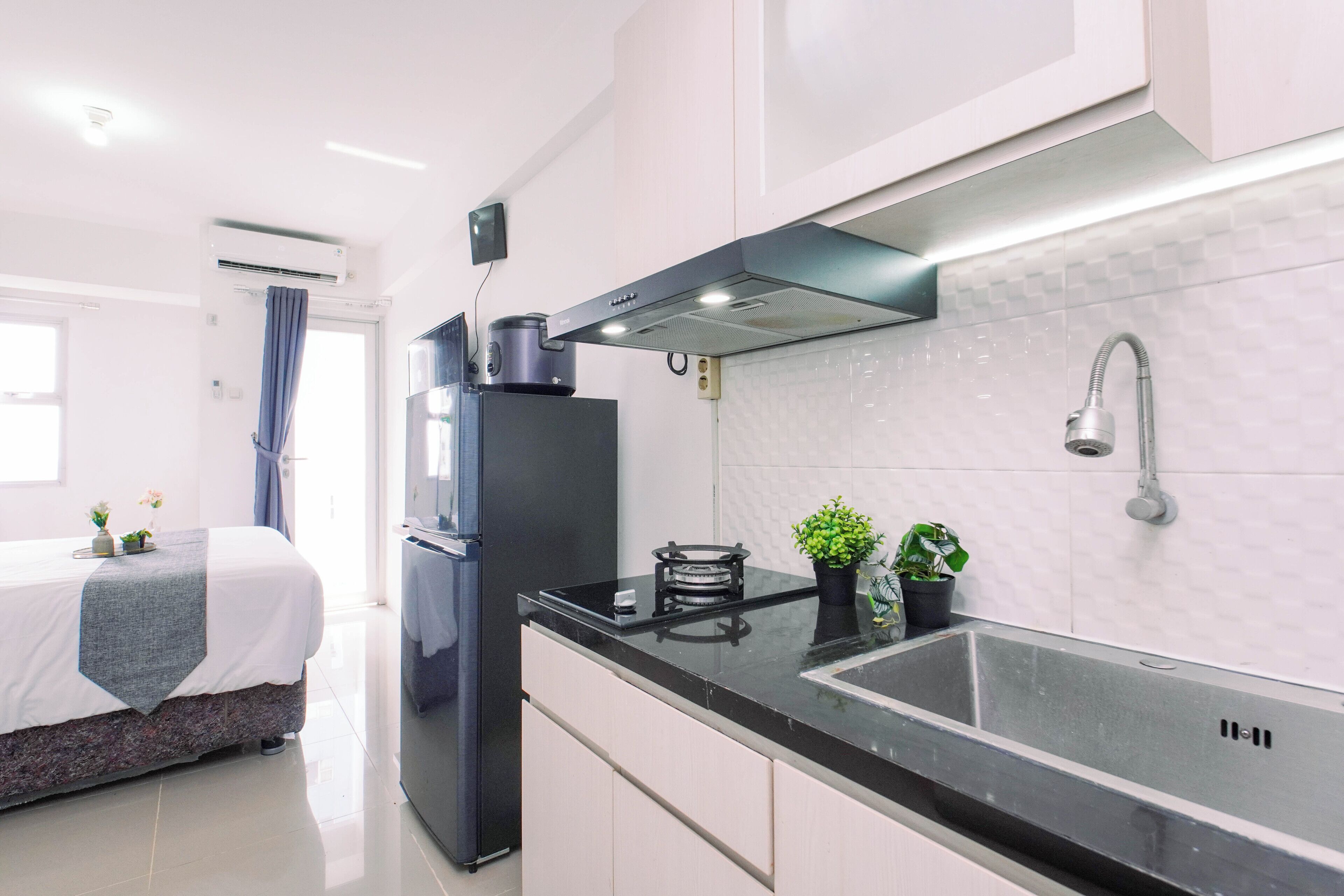 A modern kitchen with a black countertop, stainless steel appliances, and a built-in sink.