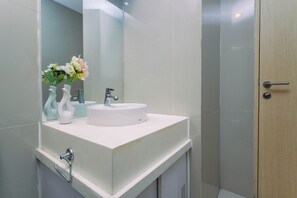 A bathroom with a white sink, a mirror, and a shower door. - Comfortable And Homey 1Br At Apartment Tree Park City Bsd (Tangerang)