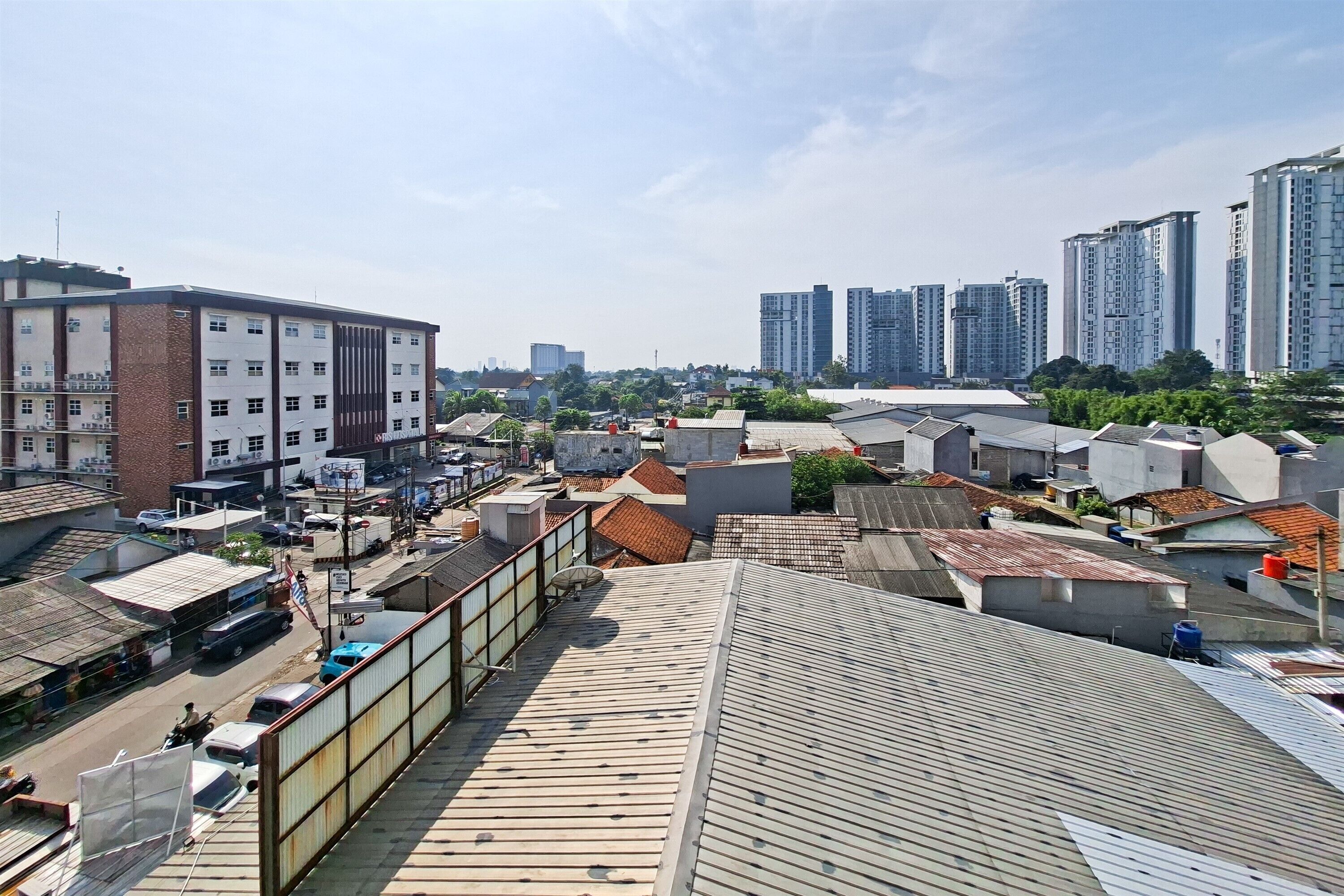 A high-rise building with multiple floors, surrounded by other buildings and a clear sky.
