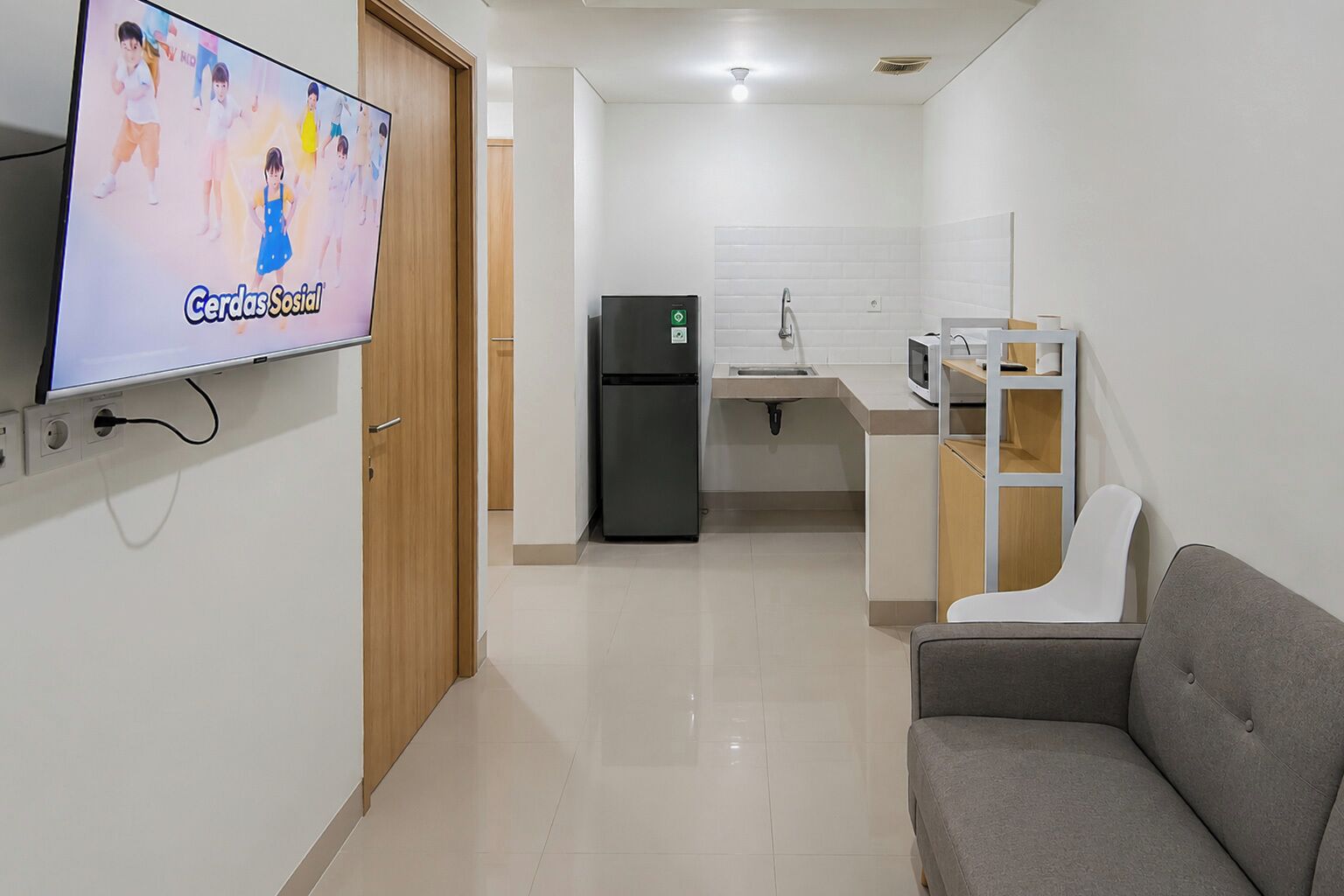 A modern kitchen with a refrigerator, microwave, and sink.