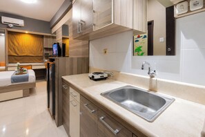 A modern kitchen with a stainless steel sink, wooden cabinets, and a built-in oven.