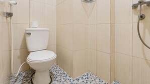 A bathroom with a toilet, a shower, and a tiled floor. - Calming Wooden Touch Studio Room At Apartment Soekarno Hatta (Suhat) Malang (Malang)