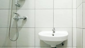 A bathroom with a white sink and a shower. - Comfortable Studio (No Kitchen) At Apartment Bandaraya - Tallasa City Makassar (Makassar (Ujung Pandang))