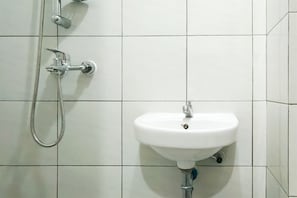 Ein Badezimmer mit einem weißen Waschbecken und einer Dusche.