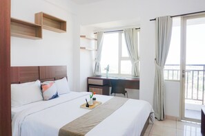 A hotel room with a bed, a desk, a chair, and a window with curtains. - Decent And Homey Studio Room At Apartment Margonda Residence 5 (Depok)