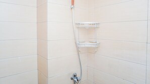 Een douche met een handdouche en een wandplank.