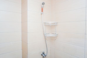 A shower with a handheld showerhead and a wall-mounted shelf. - Decent And Homey Studio Room At Apartment Margonda Residence 5 (Depok)