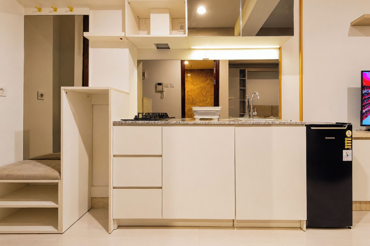 A compact kitchen with a built-in stove, a sink, and a refrigerator.