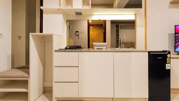 A compact kitchen with a built-in stove, a sink, and a refrigerator.