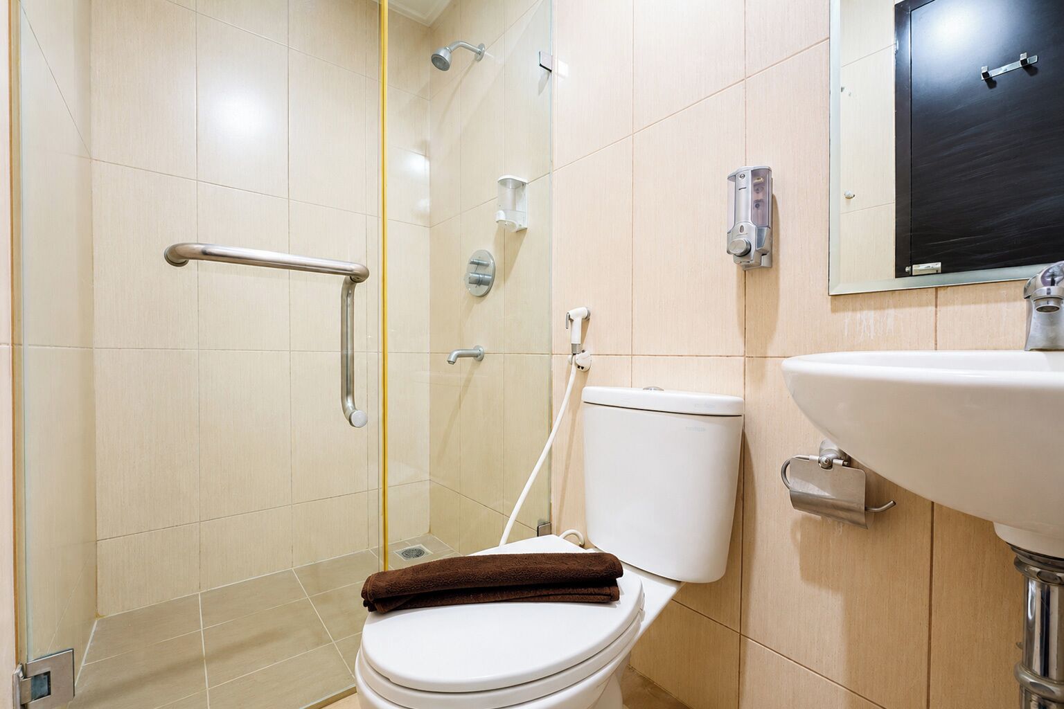 A bathroom with a toilet, a shower, and a sink.