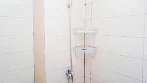 A shower with a chrome faucet and a clear plastic shelf. - Cozy And Relaxing Studio At Apartment Margonda Residence 5 (Depok)