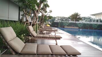 A poolside area with lounge chairs and a pool.