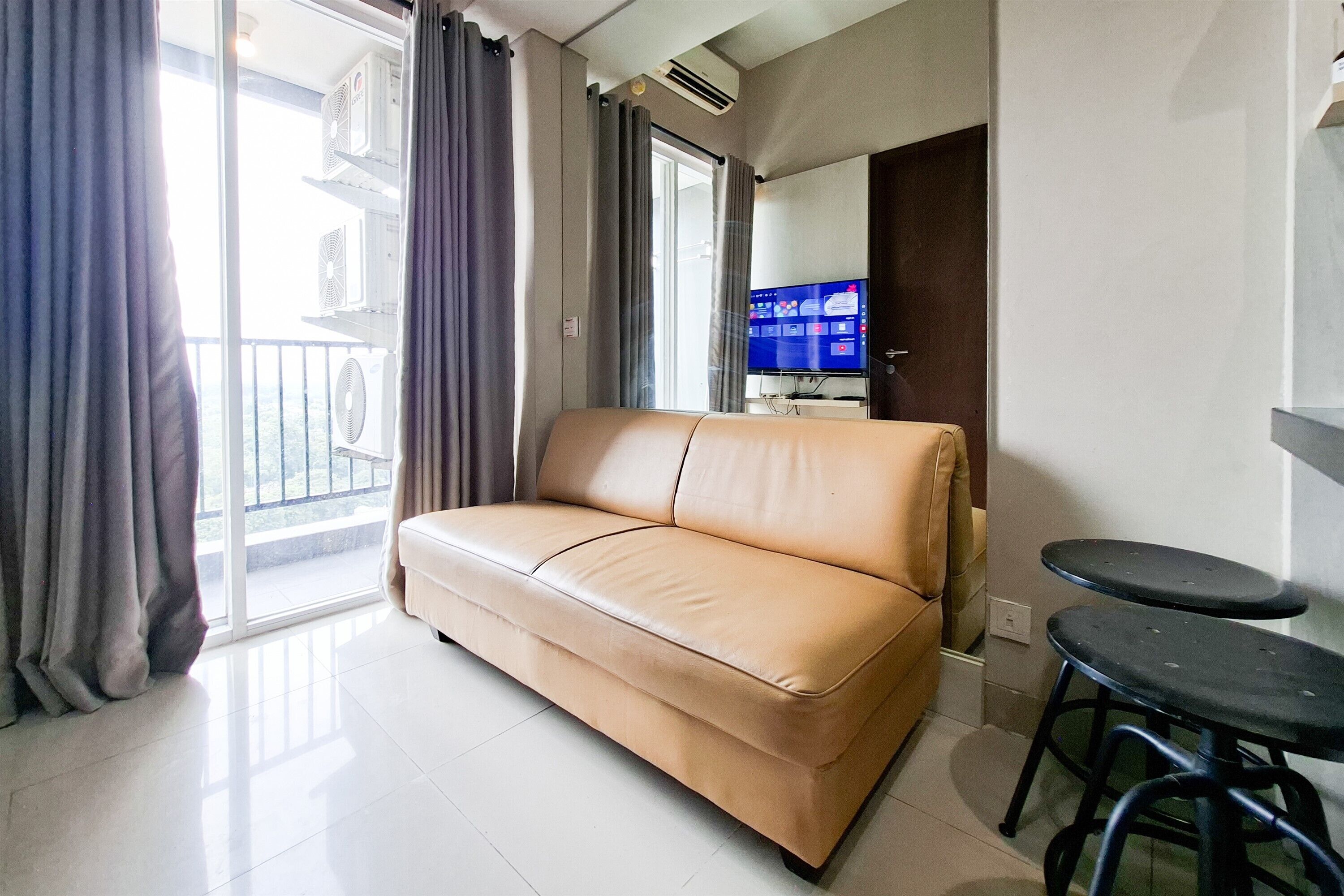 A living room with a sofa, a television, and a small table.