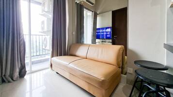 A living room with a sofa, a television, and a small table.