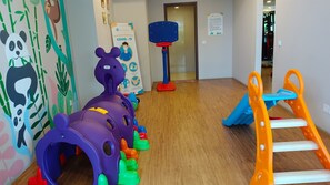 A children's play area with a purple tunnel, a basketball hoop, and an orange slide. - Comfortable Modern Look 2Br At Apartment Parkland Avenue (Tangerang)