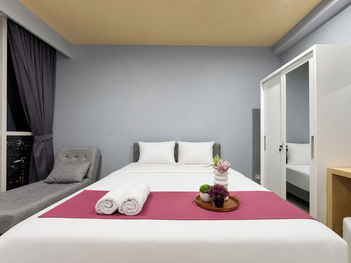 Una habitación de hotel con una cama, zona de estar y armario.