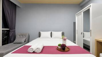 Una habitación de hotel con una cama, zona de estar y armario.