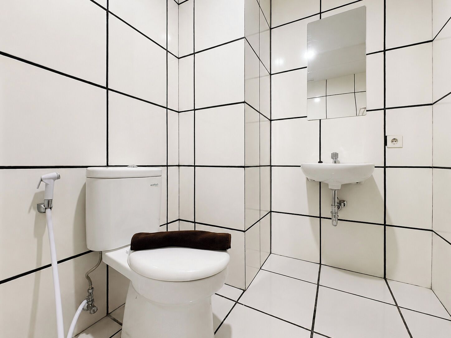 Ein modernes Badezimmer mit Toilette, Waschbecken und Spiegel.