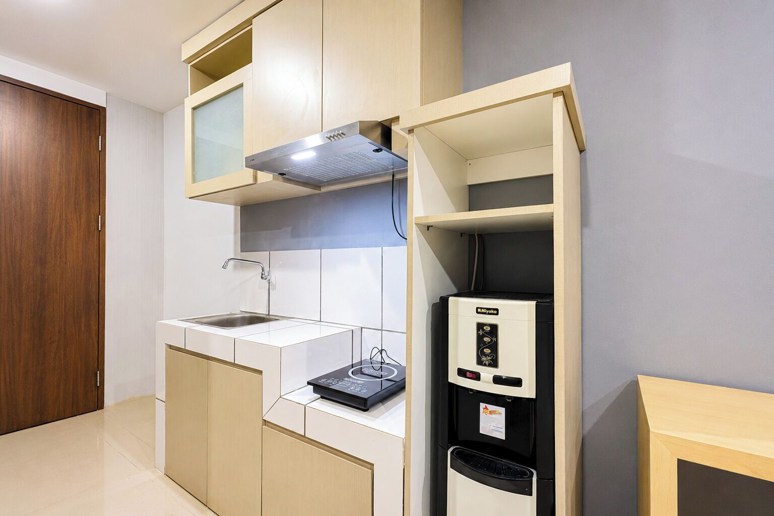A compact kitchen with a built-in stove, a sink, and a refrigerator.