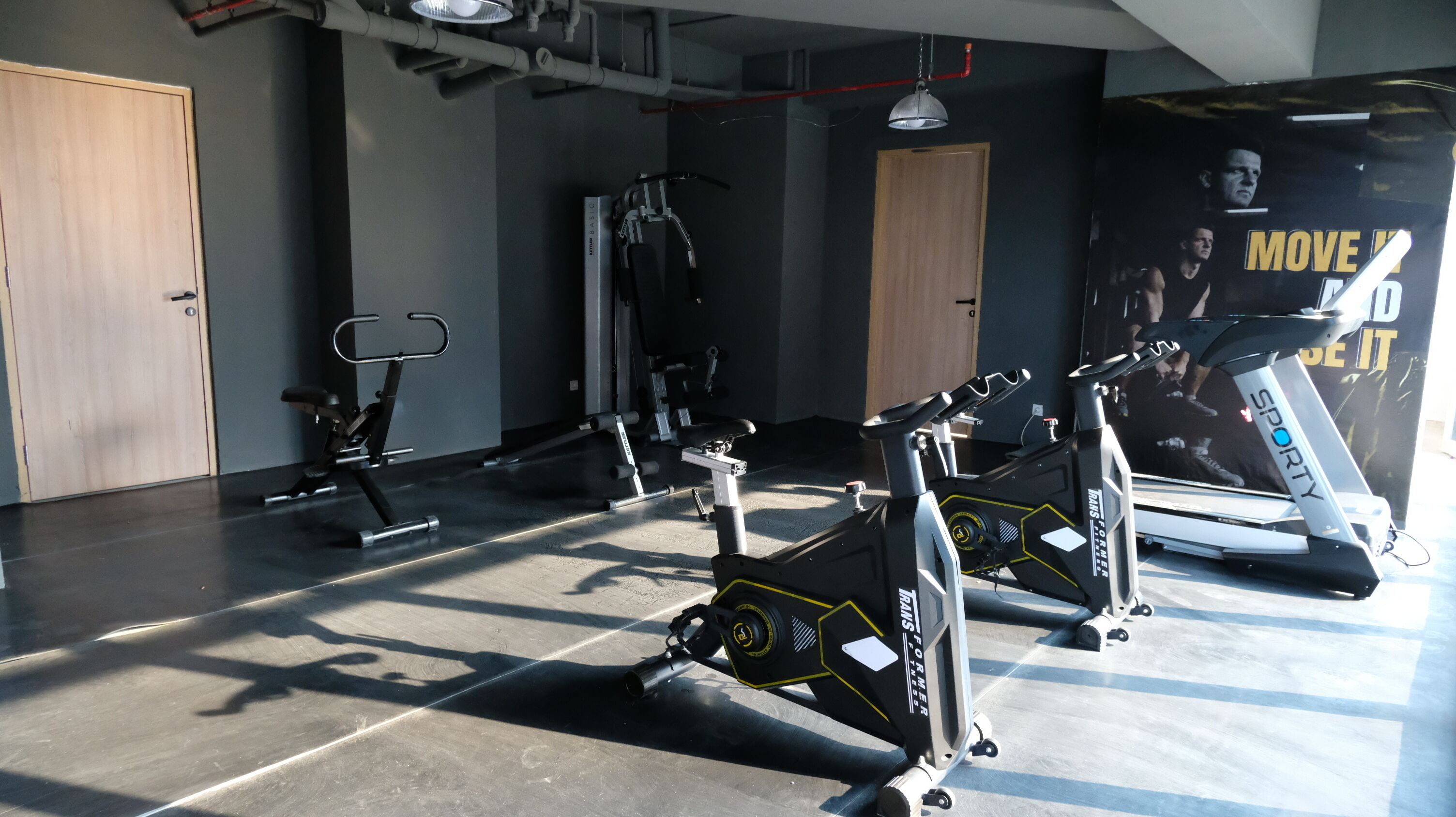 A gym with stationary bikes, treadmills, and weight machines.