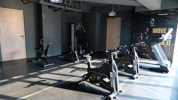 A gym with stationary bikes, treadmills, and weight machines.