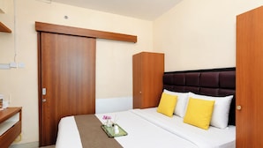A hotel room with a bed, a bedside table, a wardrobe, and a mirror. - Comfortable 1Br Without Living Room At Grand Kamala Lagoon Apartment (Bekasi)