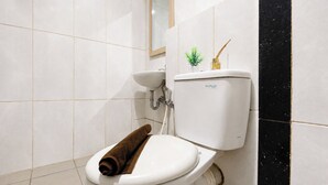 Un bany amb vàter blanc, un lavabo i un mirall.
