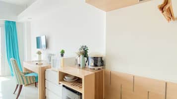 A modern kitchen with a built-in microwave, a refrigerator, and a wooden cabinet.