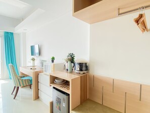 Una cuina moderna amb microones integrat, nevera i armari de fusta.