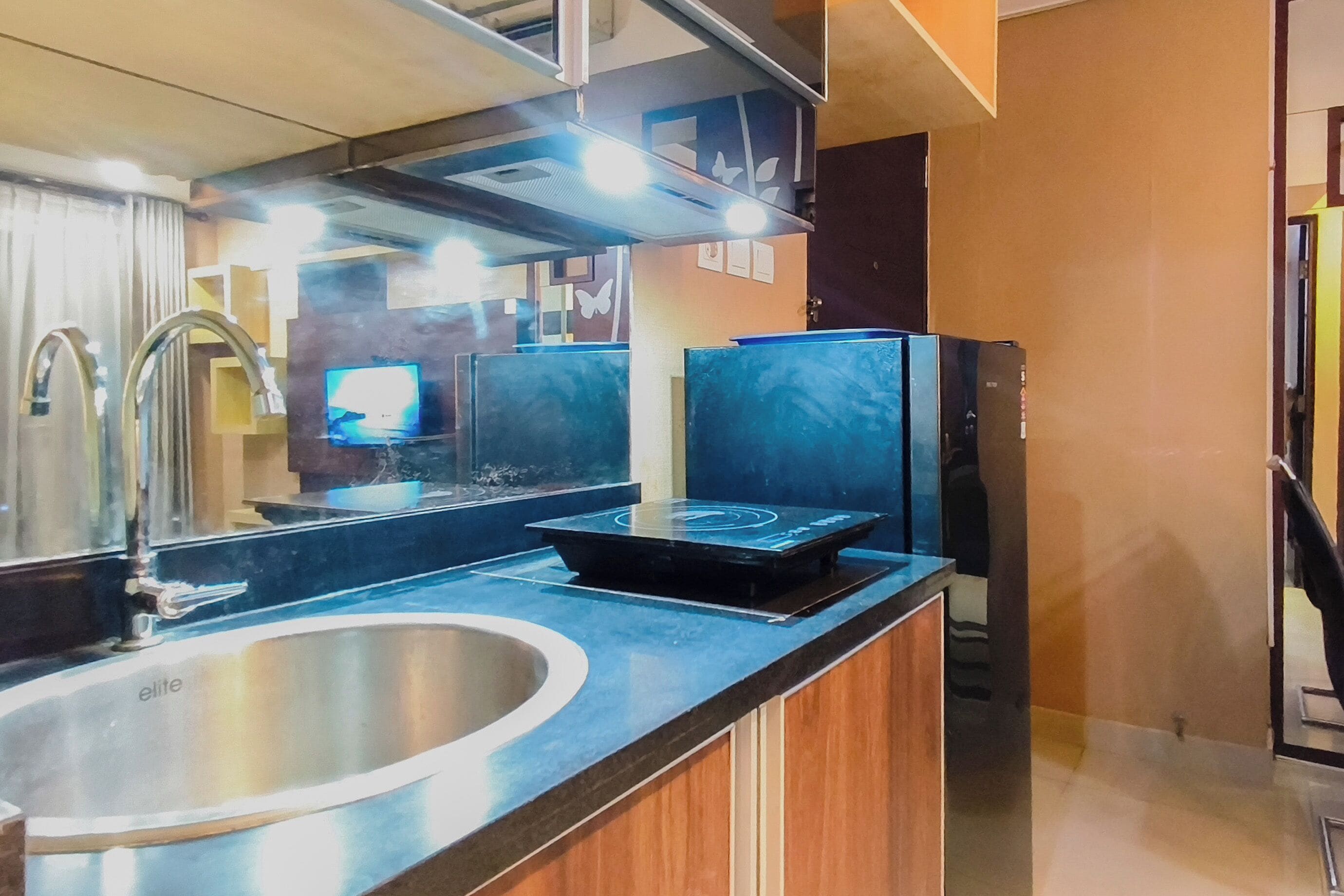 Cozinha moderna com pia de aço inoxidável, fogão embutido e micro-ondas.