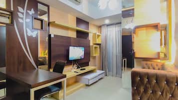 Una sala de estar moderna con un televisor de pantalla plana, un sofá marrón con capitonado, un escritorio de madera y un mueble empotrado para entretenimiento.