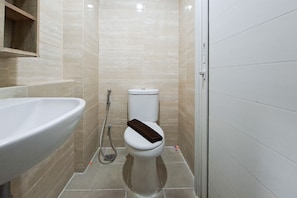 A bathroom with a white sink, toilet, and shower. - Airy Minimalist Studio Apartment At Springwood Residence Tangerang (Tangerang)