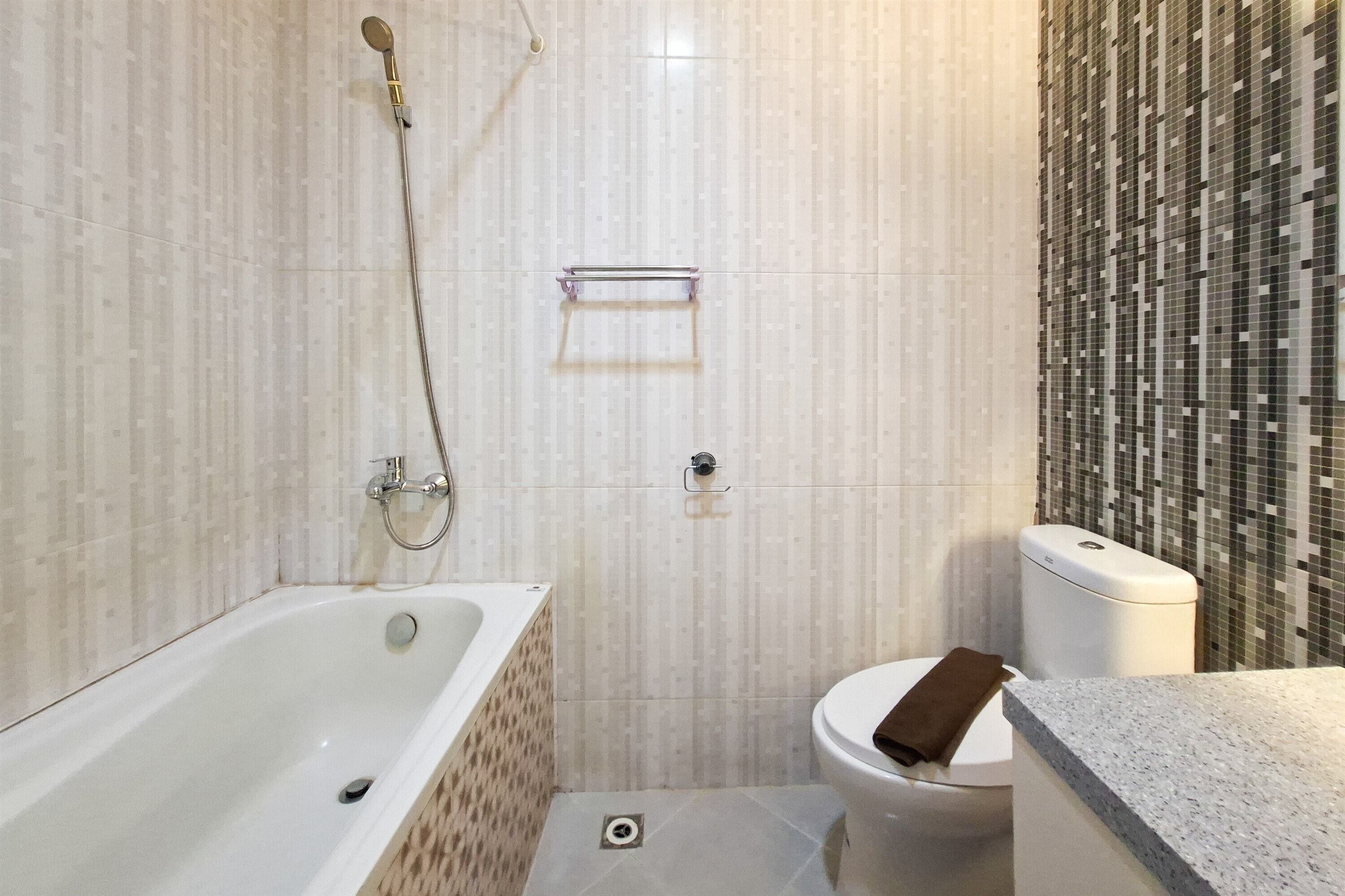 Un baño con bañera, inodoro y ducha.
