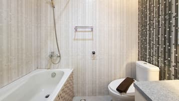 Un baño con bañera, inodoro y ducha.