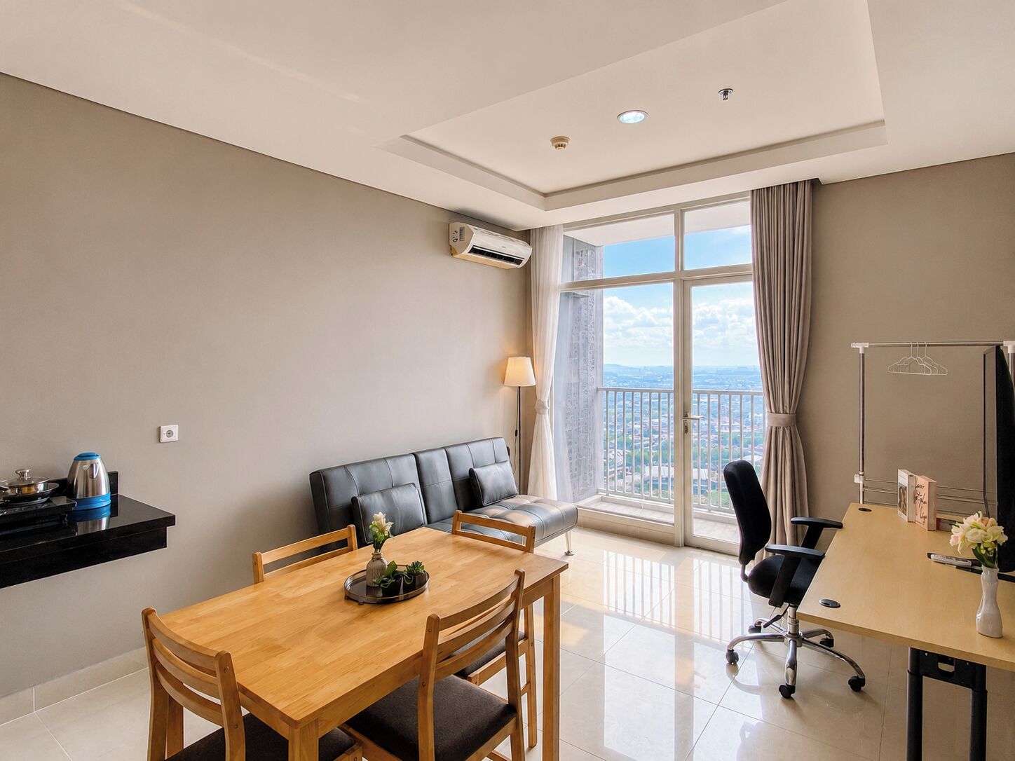 A modern living room with a dining area, a sofa, a table, and a view of the city.