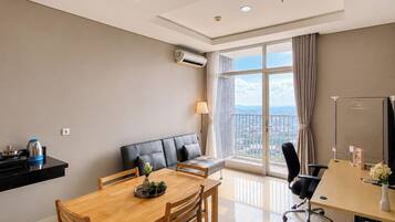 A modern living room with a dining area, a sofa, a table, and a view of the city.