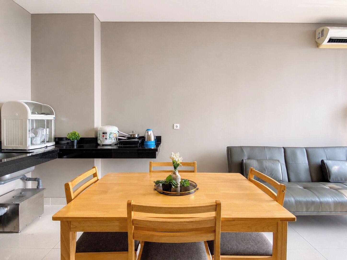 A modern kitchen with a coffee machine, a kettle, and a toaster on the countertop.