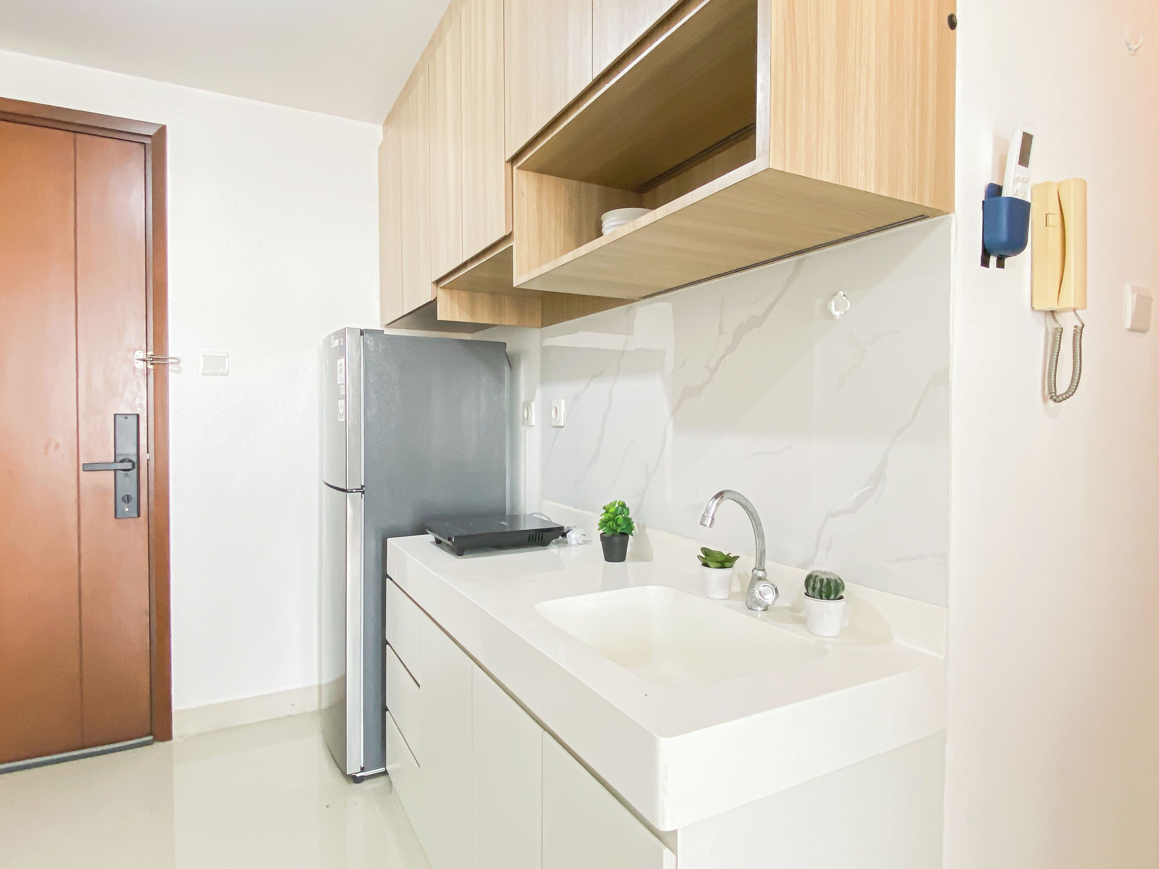 A modern kitchen with a built-in refrigerator, a sink, and wooden cabinets.