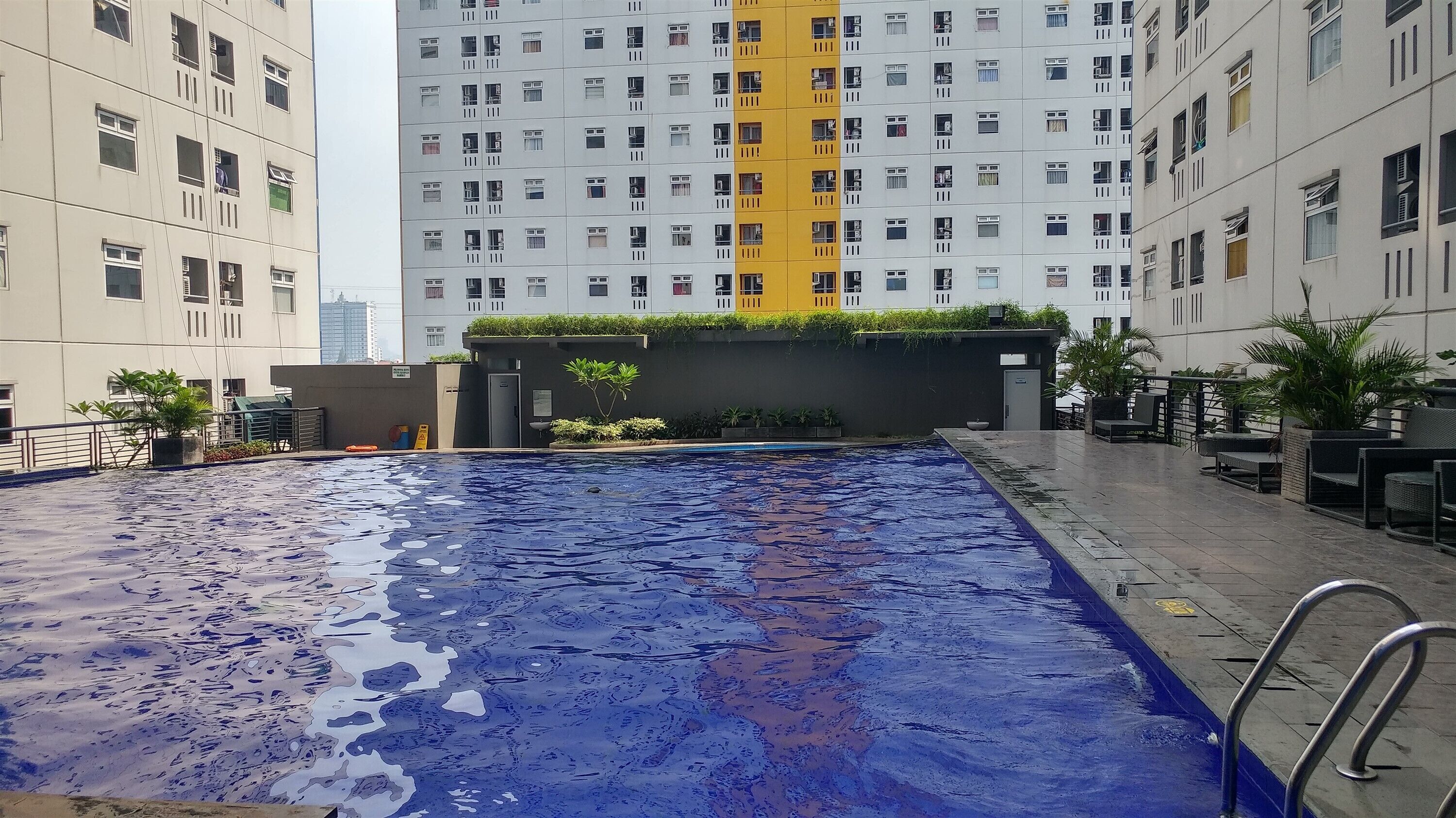 Una piscina con vistas a edificios altos en el fondo.