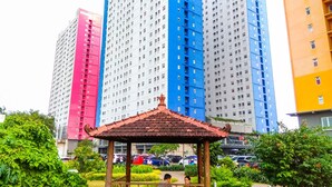 Un padiglione in un parco con vista su alti edifici residenziali sullo sfondo.