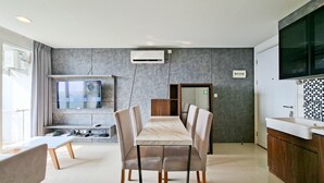 A modern kitchen with a dining area, a built-in TV, and a large window. - Bright And Convenient 2Br At Apartment Tuscany Residence (Tangerang)